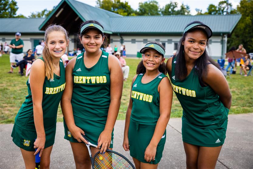 Four tennis players smile
